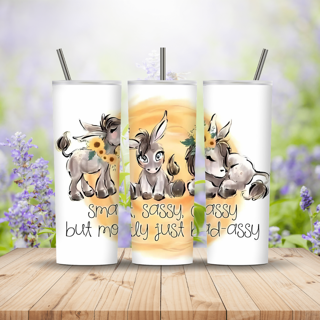 three white tumblers with images and text on a wooden background
