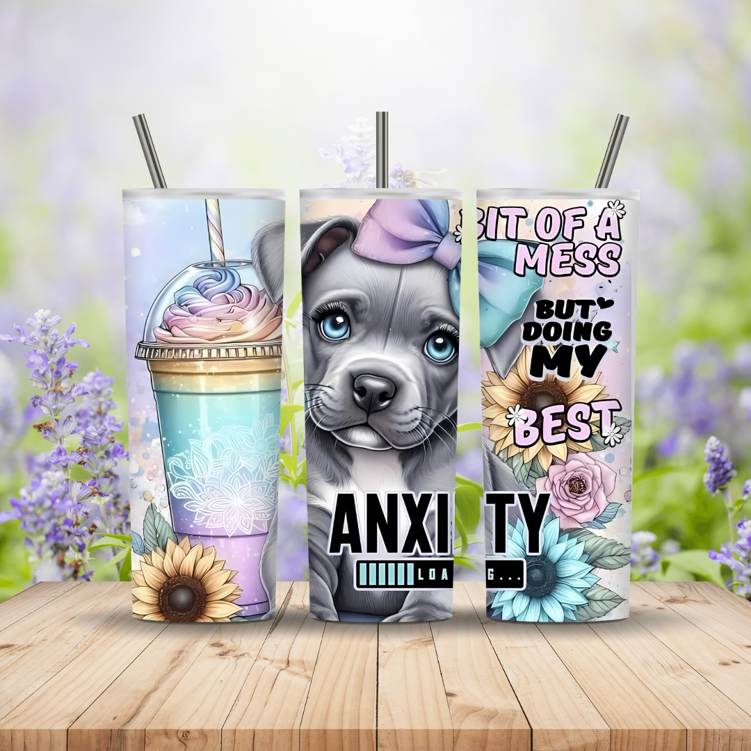 Three tumblers with designs and text on a wooden surface with a blurred floral background