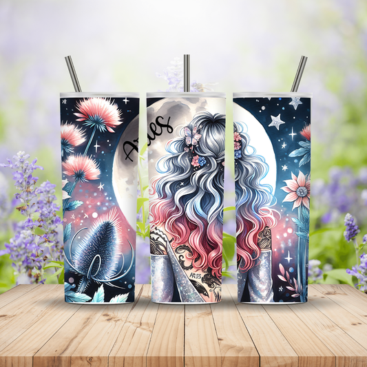 Three tumblers with artistic designs on a wooden surface with a blurred floral background