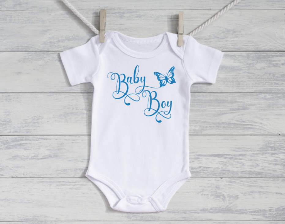 White baby onesie with 'Baby Boy' text and butterfly graphic on a wooden surface