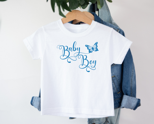 White t-shirt with 'Baby Boy' text and butterfly graphic on a hanger with denim jacket.
