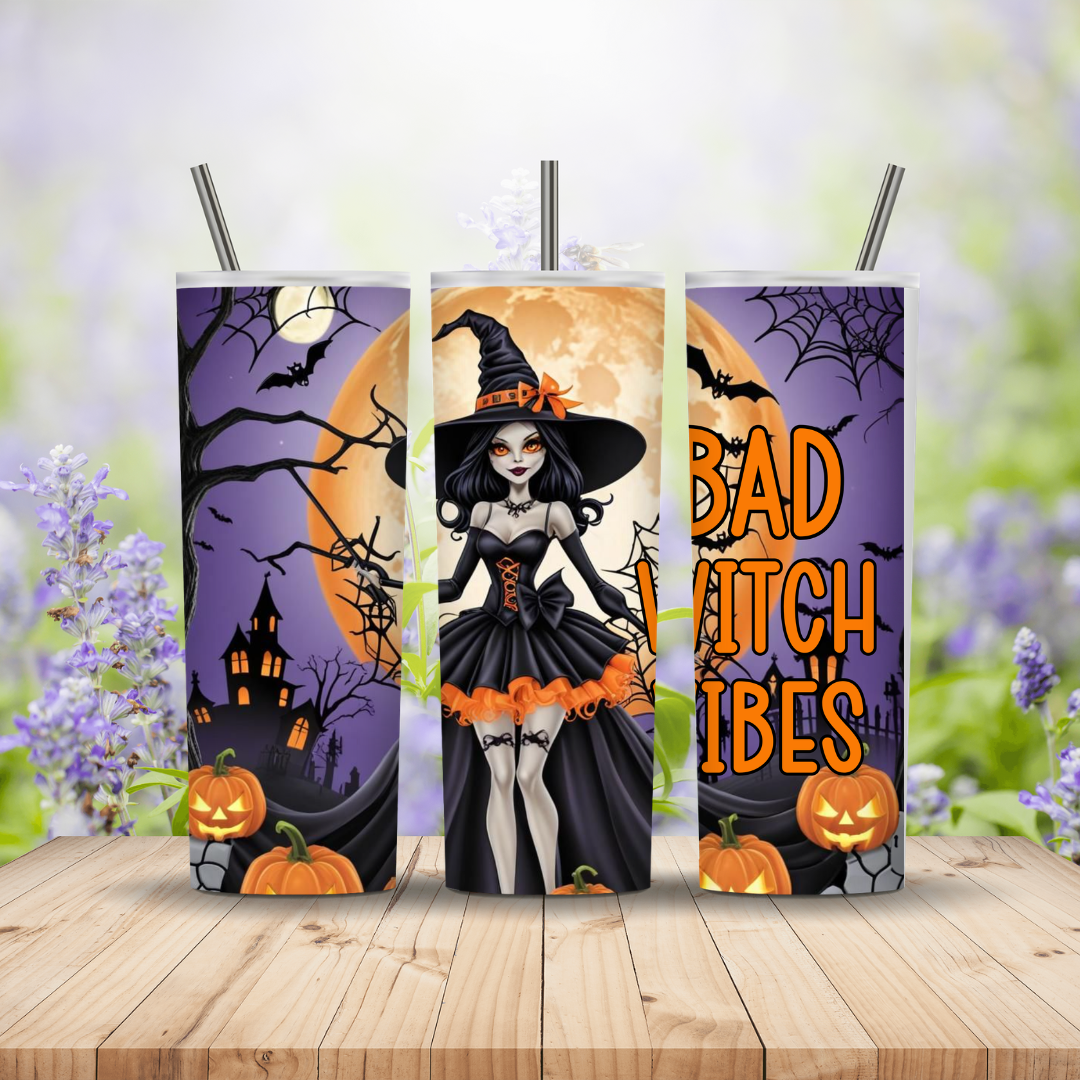 Three Halloween-themed tumblers with witch designs on a wooden surface.