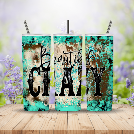 Three tumbler cups with decorative designs and text on a wooden surface with a blurred floral background.