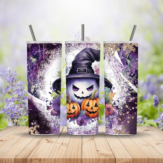 Three Halloween-themed tumblers with a witch design on a wooden surface with blurred floral background