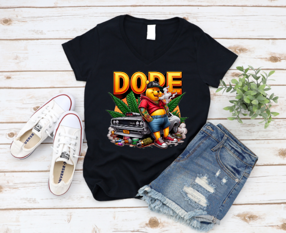 Black t-shirt featuring a bold 'DOPE' graphic with a tattooed bear in streetwear, leaning against a muscle car surrounded by smoke, weed leaves, and urban details.