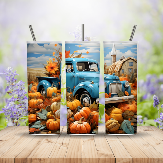 Three tumblers of a blue truck with pumpkins and autumn scenery on a wooden surface.