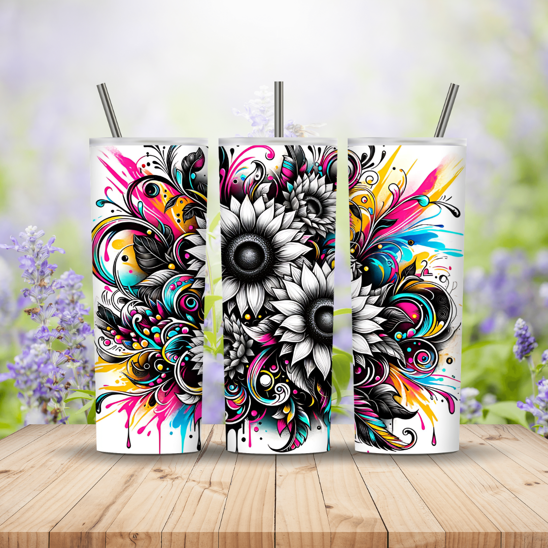 Three colorful tumblers with floral designs on a wooden surface with a blurred floral background.