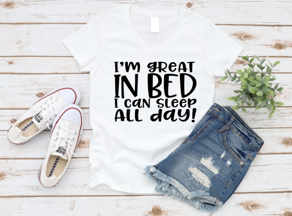 White t-shirt with humorous text, denim shorts, and sneakers on a wooden surface.