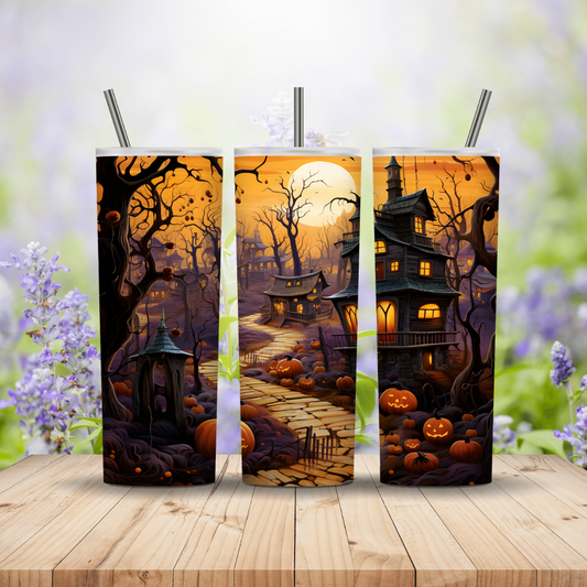 Three Halloween-themed tumblers with a haunted house design on a wooden surface.