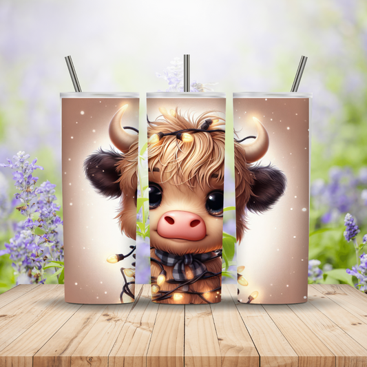 Three tumblers with a cute cow design on a wooden surface with a blurred floral background