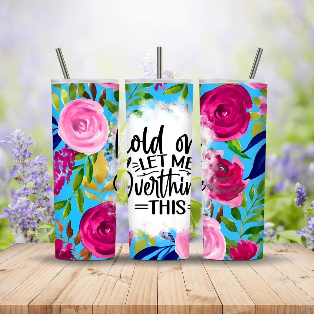Three colorful tumblers with floral designs and text on a wooden surface.