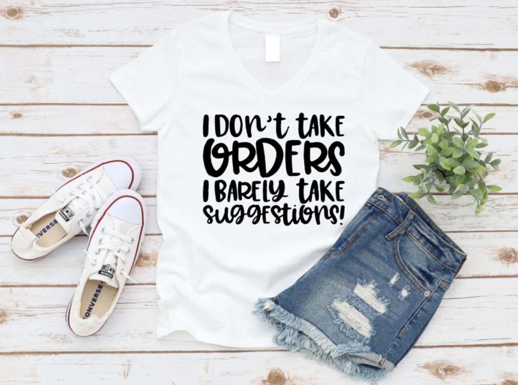 White t-shirt with humorous text, denim shorts, and white sneakers on a wooden surface.