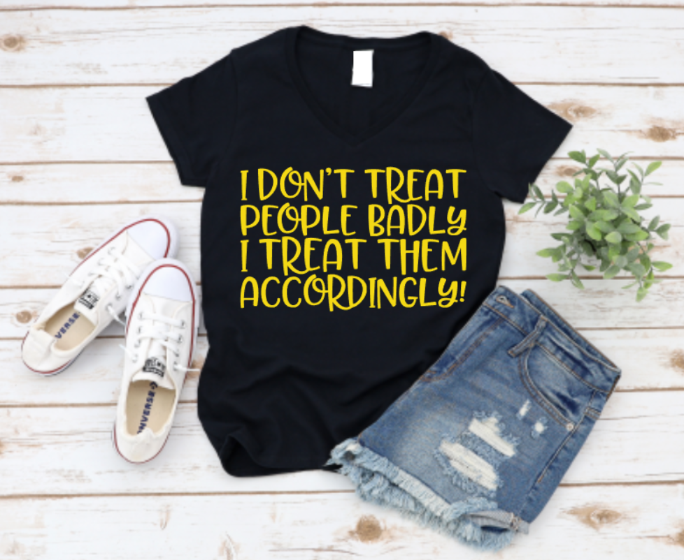 Black t-shirt with yellow text, white sneakers, and denim shorts on a wooden surface.