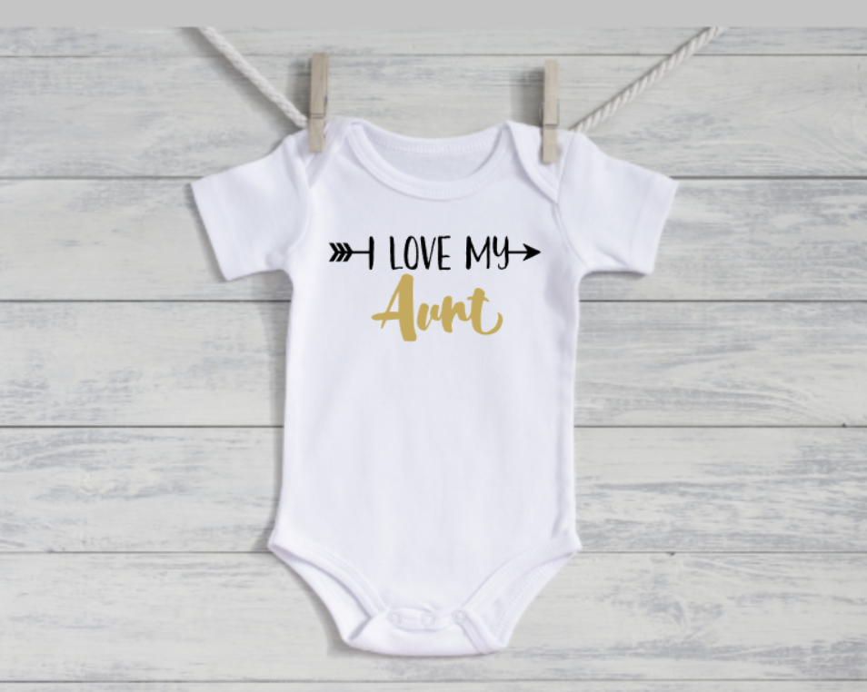 White baby onesie with 'I Love My Aunt' text on a wooden surface