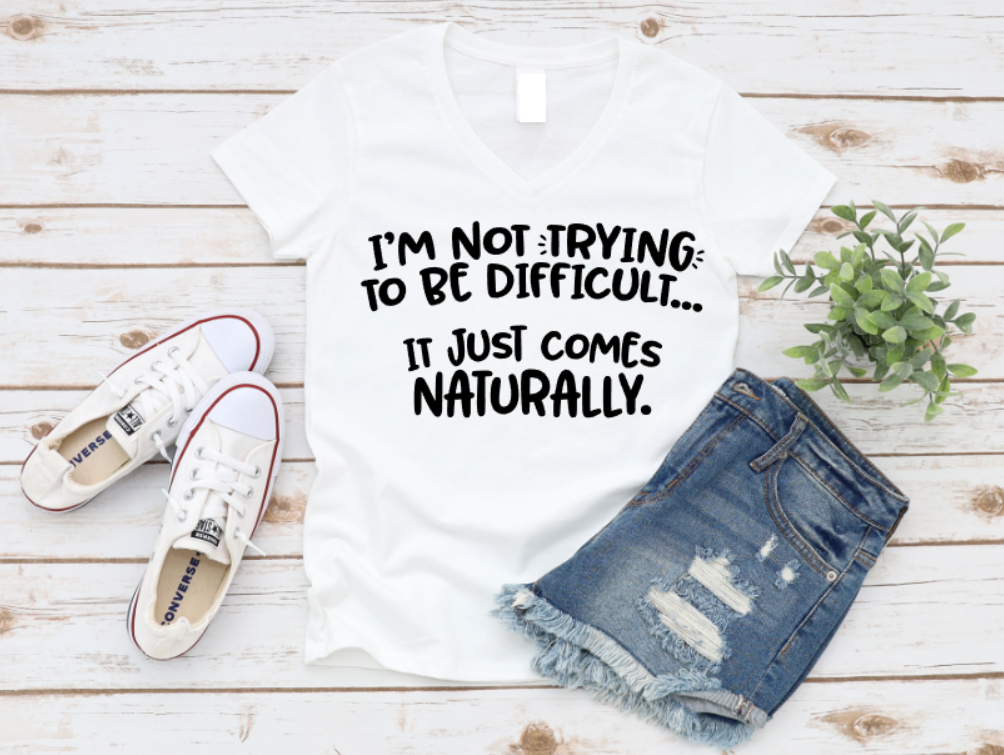 White t-shirt with text, white sneakers, and denim shorts on a wooden surface. www.missmafia.com