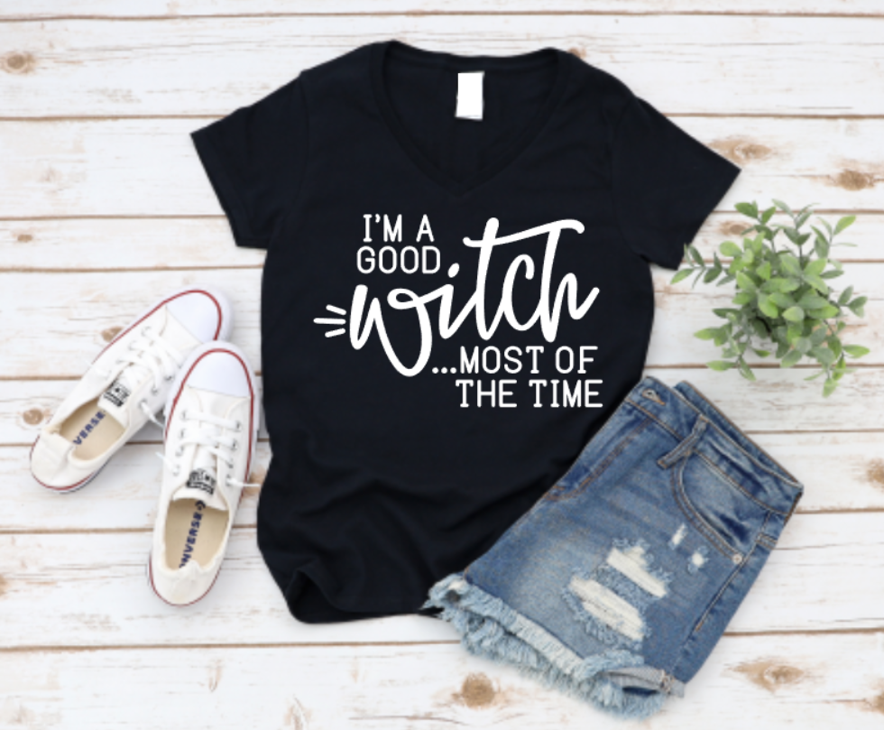 Black t-shirt with 'I'm a good witch most of the time' text, paired with white sneakers and denim shorts on a wooden surface. Shop now www.missmafia.com