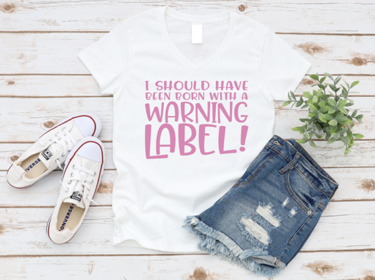 White t-shirt with pink text, white sneakers, and denim shorts on a wooden surface. www.missmafia.com
