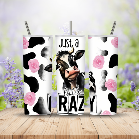Three tumbler designs with cow and floral patterns on a wooden surface with a blurred floral background.
