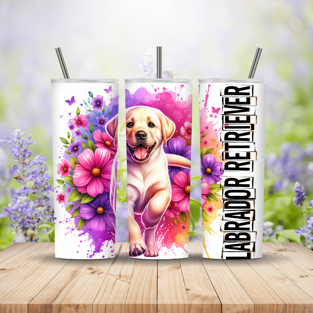 Three tumblers with Labrador Retriever designs on a wooden surface with a blurred floral background.