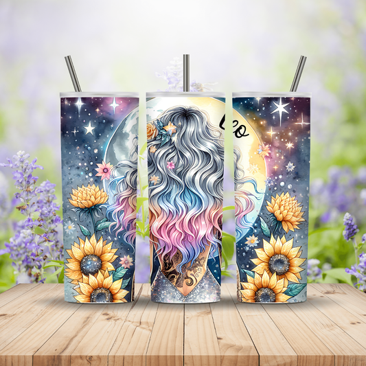 Three tumbler designs with a colorful character, flowers, and celestial elements on a wooden surface with a blurred floral background.