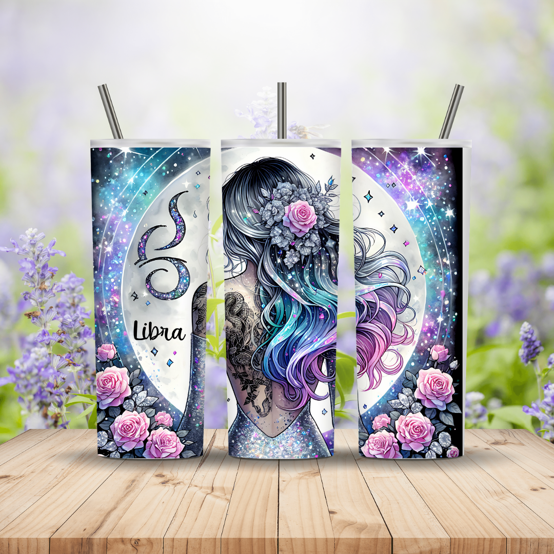 Three colorful tumbler designs with astrological symbols and floral elements on a wooden surface with a blurred floral background.