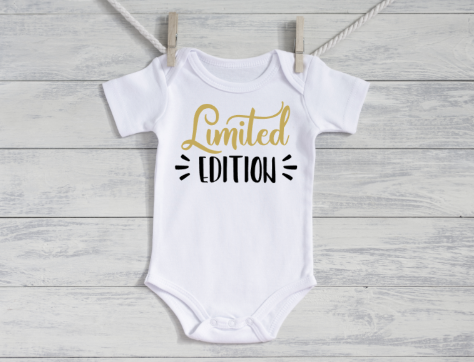 White baby onesie with 'Limited Edition' text on a wooden surface