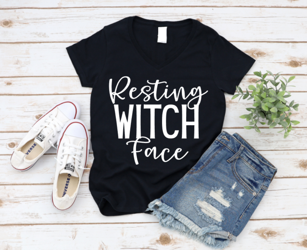 Black t-shirt with 'Resting Witch Face' text, paired with denim shorts and white sneakers on a wooden surface. www.missmafia.com