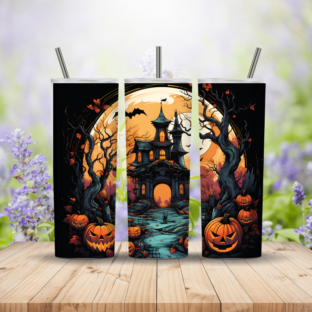 Three Halloween-themed tumblers with pumpkins, full moon, and haunted house design on a wooden surface with blurred floral background.