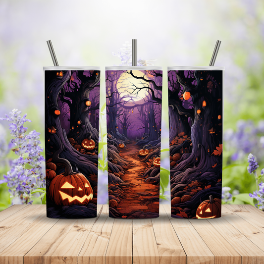 Three Halloween-themed tumblers with pumpkins and a forest design on a wooden surface with a blurred floral background.