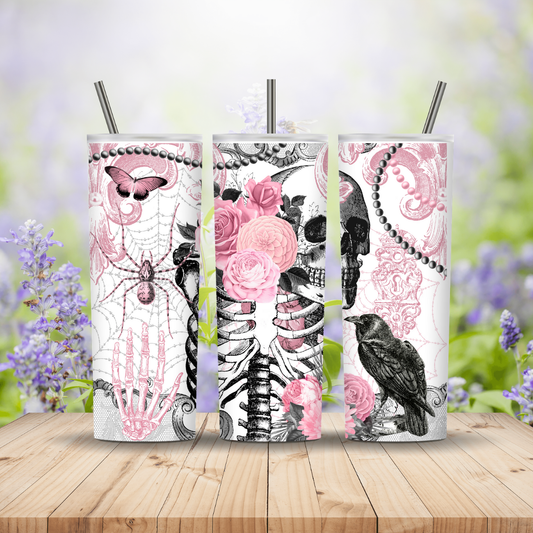 Three tumblers with decorative designs on a wooden surface with a blurred floral background