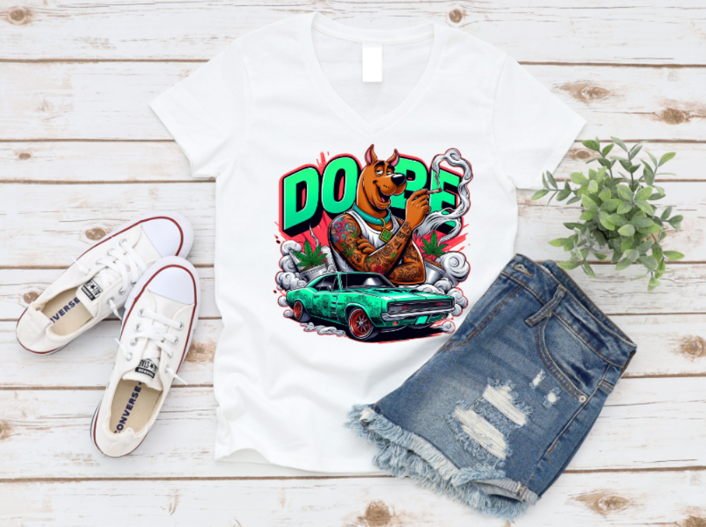 White t-shirt featuring a tattooed, muscular cartoon dog, smoking with bold “DOPE” text in the background, a green muscle car, smoke clouds, and weed leaves in a vibrant, urban graffiti style.