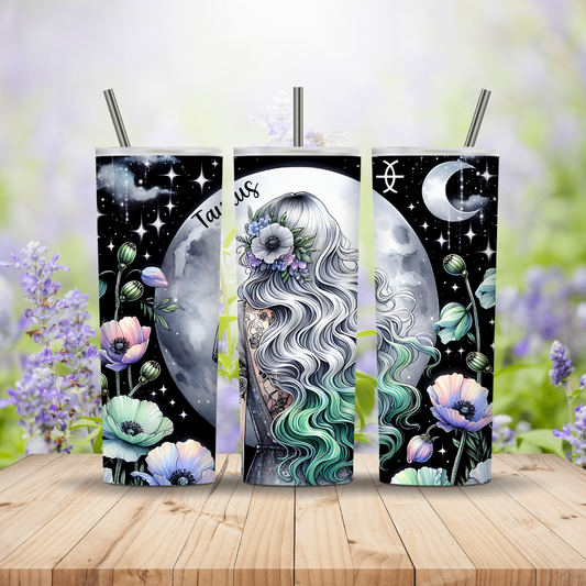 Three tumbler designs with a woman's face, flowers, and celestial elements on a wooden surface with a blurred floral background.