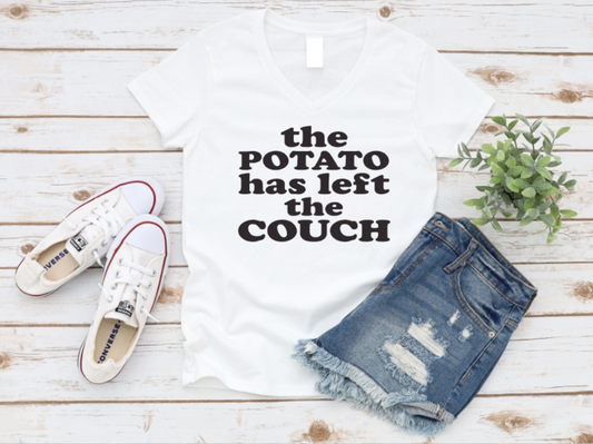 White t-shirt with 'the POTATO has left the COUCH' text, denim shorts, and white sneakers on a wooden surface. www.missmafia.com