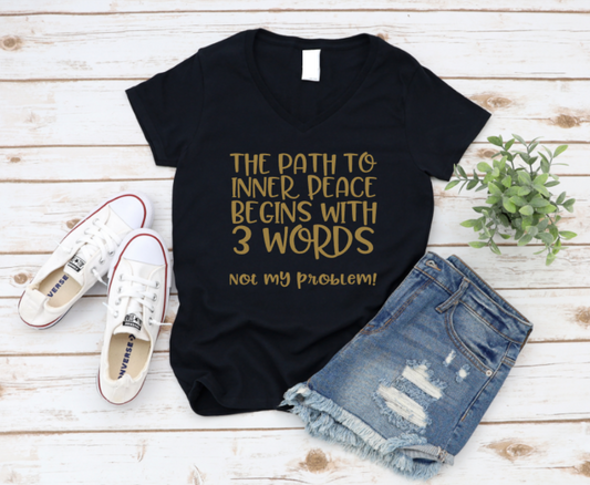 Black t-shirt with gold text on a wooden surface with shoes and shorts. www.missmafia.com