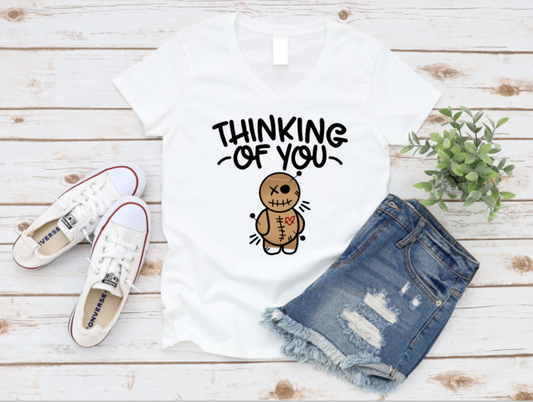White t-shirt with 'Thinking of You' text and gingerbread man graphic, paired with denim shorts and white sneakers on a wooden surface. | www.missmafia.com