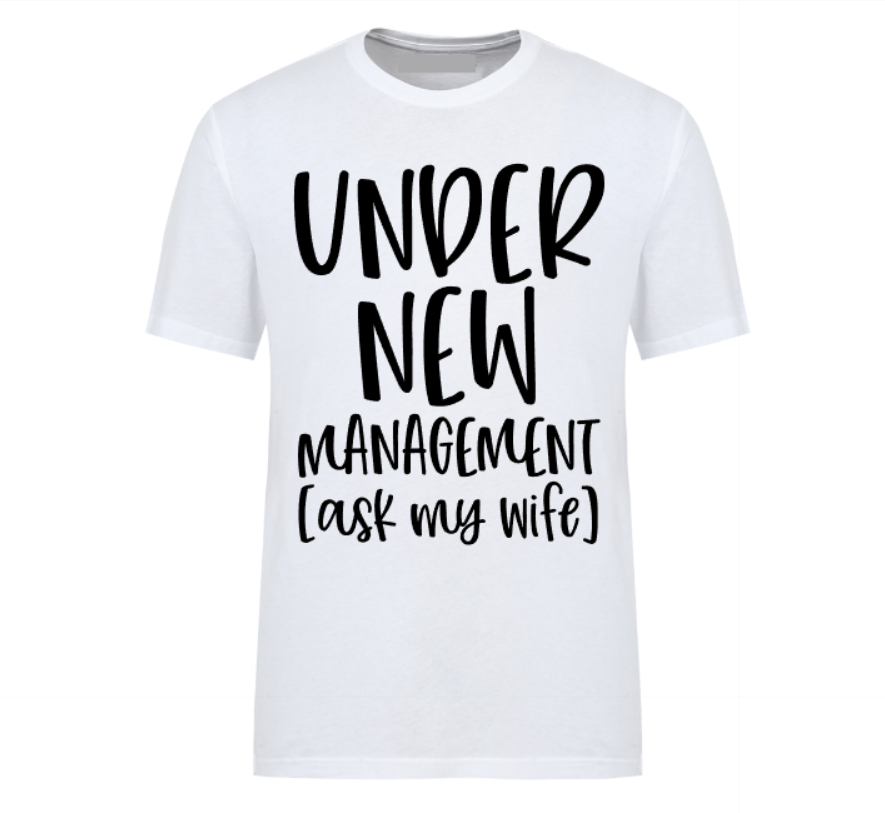 White t-shirt with bold black text reading “Under New Management – See Wife for Details,” styled with casual denim and sneakers—funny gift for husbands or newlyweds.