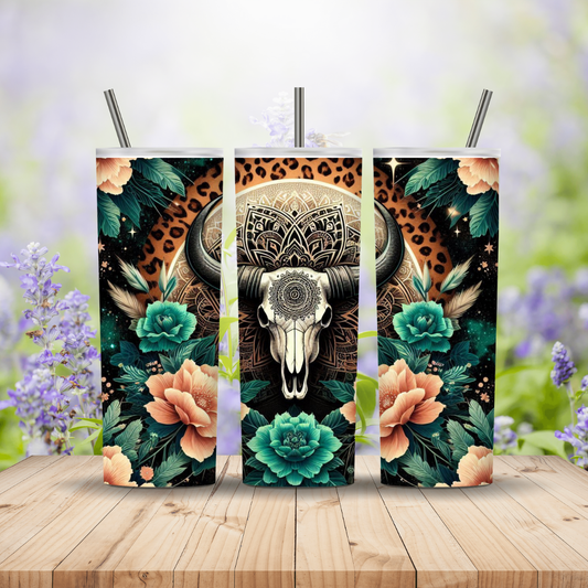 Three decorative panels with a bull skull design on a wooden surface with flowers in the background