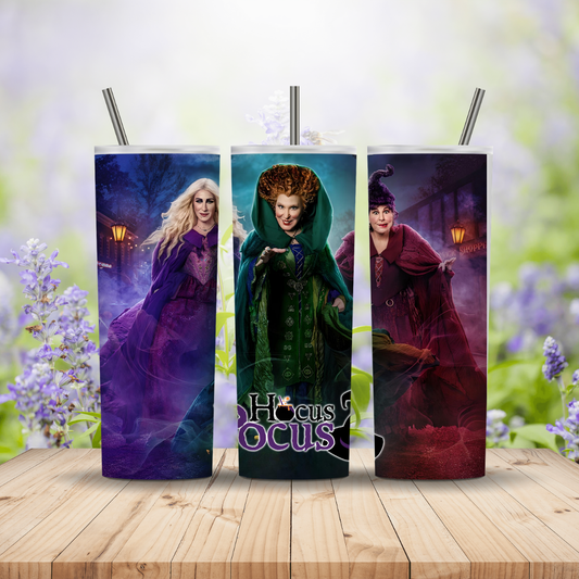 Three tumblers with 'Hocus Pocus' characters on a wooden surface with a floral background