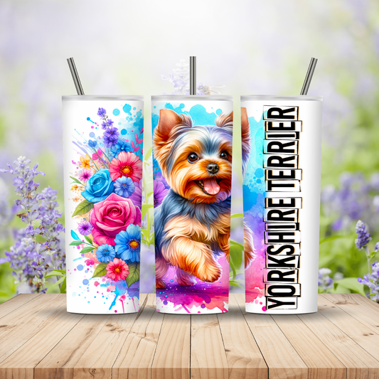 Three tumblers with floral, dog, and text designs on a wooden surface with a blurred floral background.