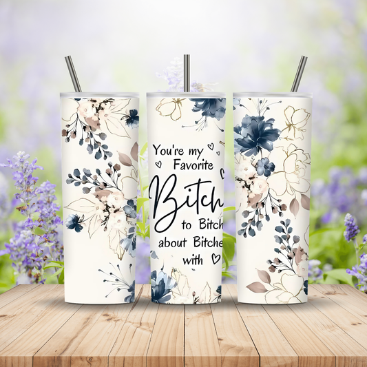 Three floral tumblers with text on a wooden surface with blurred flowers in the background