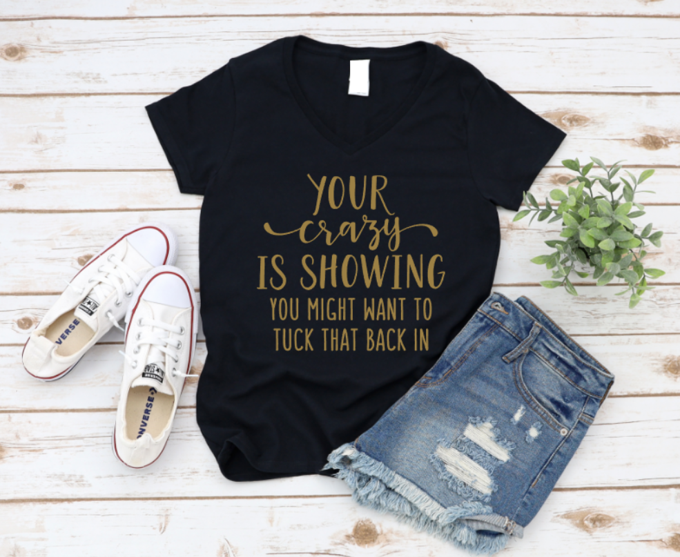 Black t-shirt with gold text, white sneakers, and denim shorts on a wooden surface. www.missmafia.com