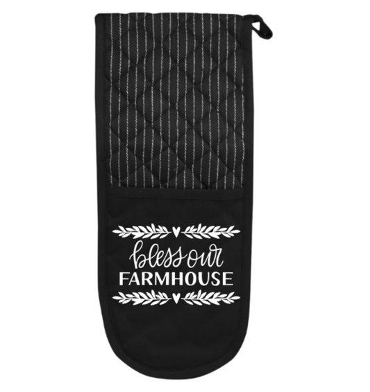 Black oven mitt with quilted pattern and 'bless our Farmhouse' text on a white background