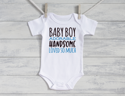 White baby onesie with text on a wooden surface