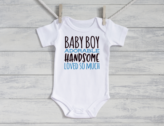 White baby onesie with text on a wooden surface