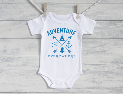 White baby onesie with blue 'Adventure Everywhere' text and graphics on a wooden surface.