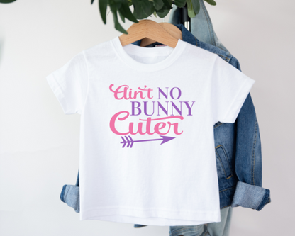 White kids t-shirt with black text that reads “Ain’t No Bunny Cuter,” featuring a fun bunny design, perfect for Easter or cute everyday wear