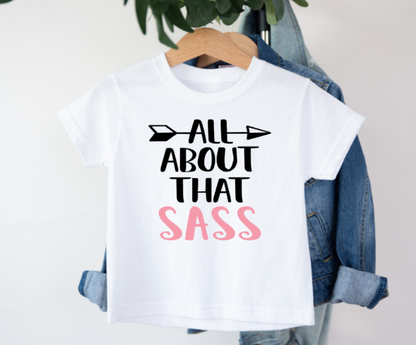 White t-shirt with 'All About That Sass' text on a hanger with denim jacket