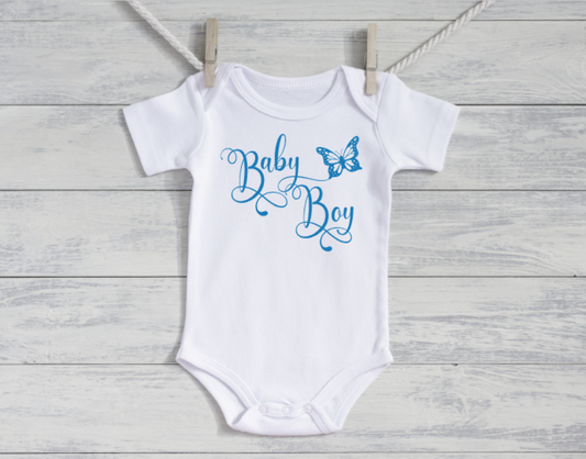 White baby onesie with 'Baby Boy' text and butterfly graphic on a wooden surface