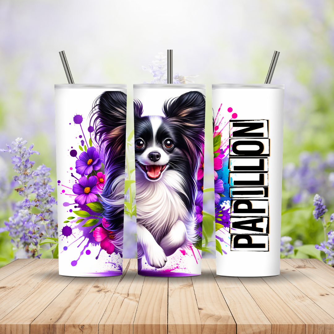 Three tumblers with a Papillon dog design on a wooden surface with a floral background.