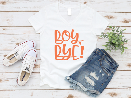 White t-shirt with bold “Boy, Bye!” text, styled with ripped denim shorts and white Converse sneakers on a rustic white wood background.